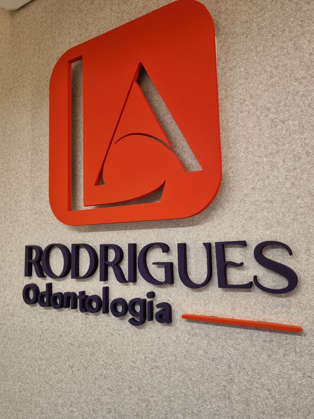 Logotipo da clínica em relevo coral e marinho